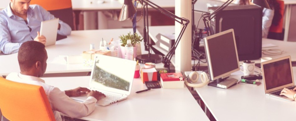 Colleagues Working Around A Shared Desk