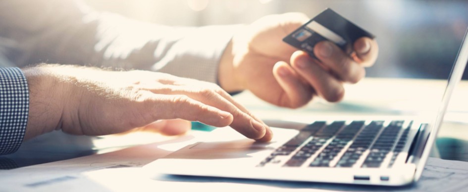 One Hand Holding A Credit Card, The Other Typing